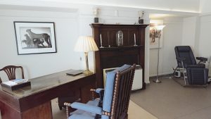 Modern clinic room featuring a contemporary desk, designed to provide a comfortable and safe space for doctors to consult with patients.